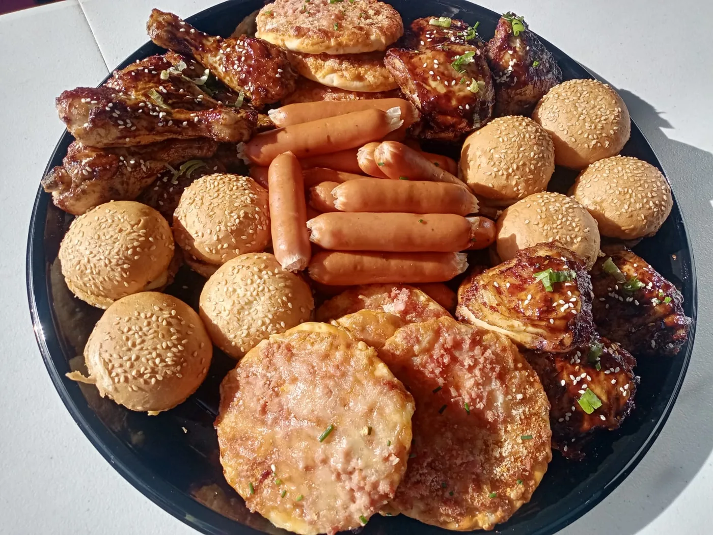 Sliders, mini pizzas and grilled chicken arranged on a platter